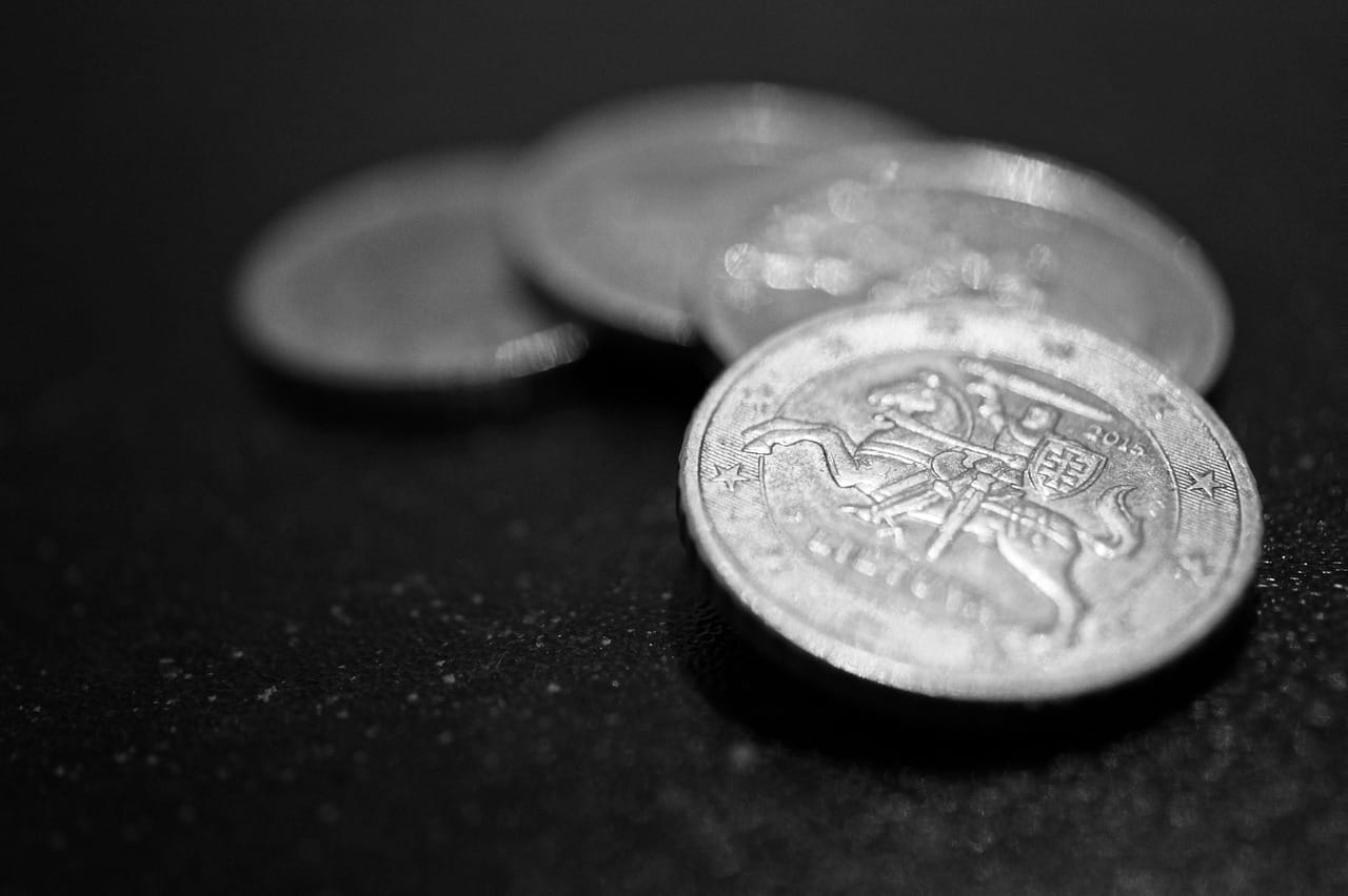 Pila de monedas sobre documentos financieros, representando la cobranza de gastos comunes y la recuperación de deudas en condominios de Chile